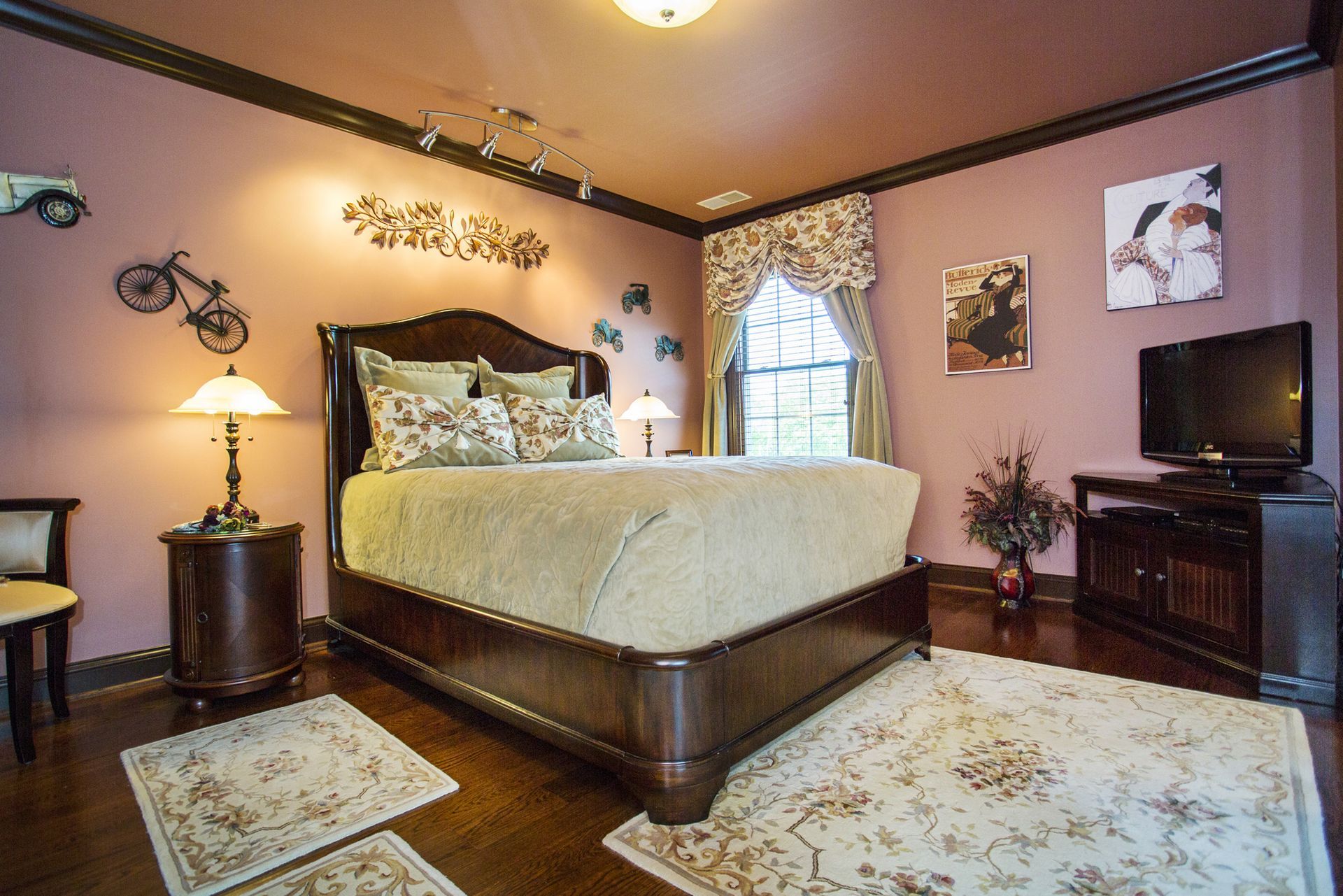 Bedroom with a dark wooden bed, mauve walls, and decorative accents.