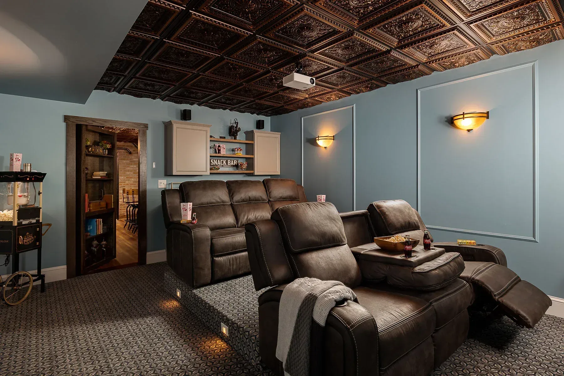 A 1920s themed home theater with a couch , chairs and a projector.