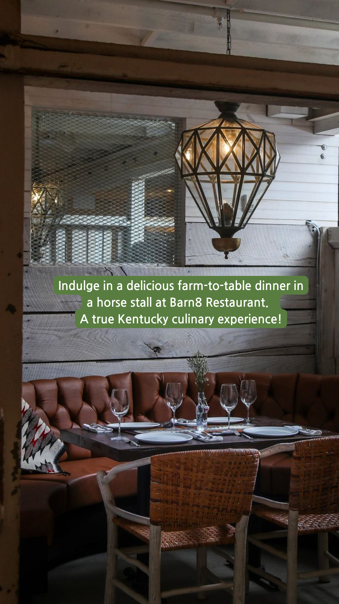 Farm-to-table dinner setting inside a horse stall at Barn Restaurant in Kentucky. Features leather booth and a light.