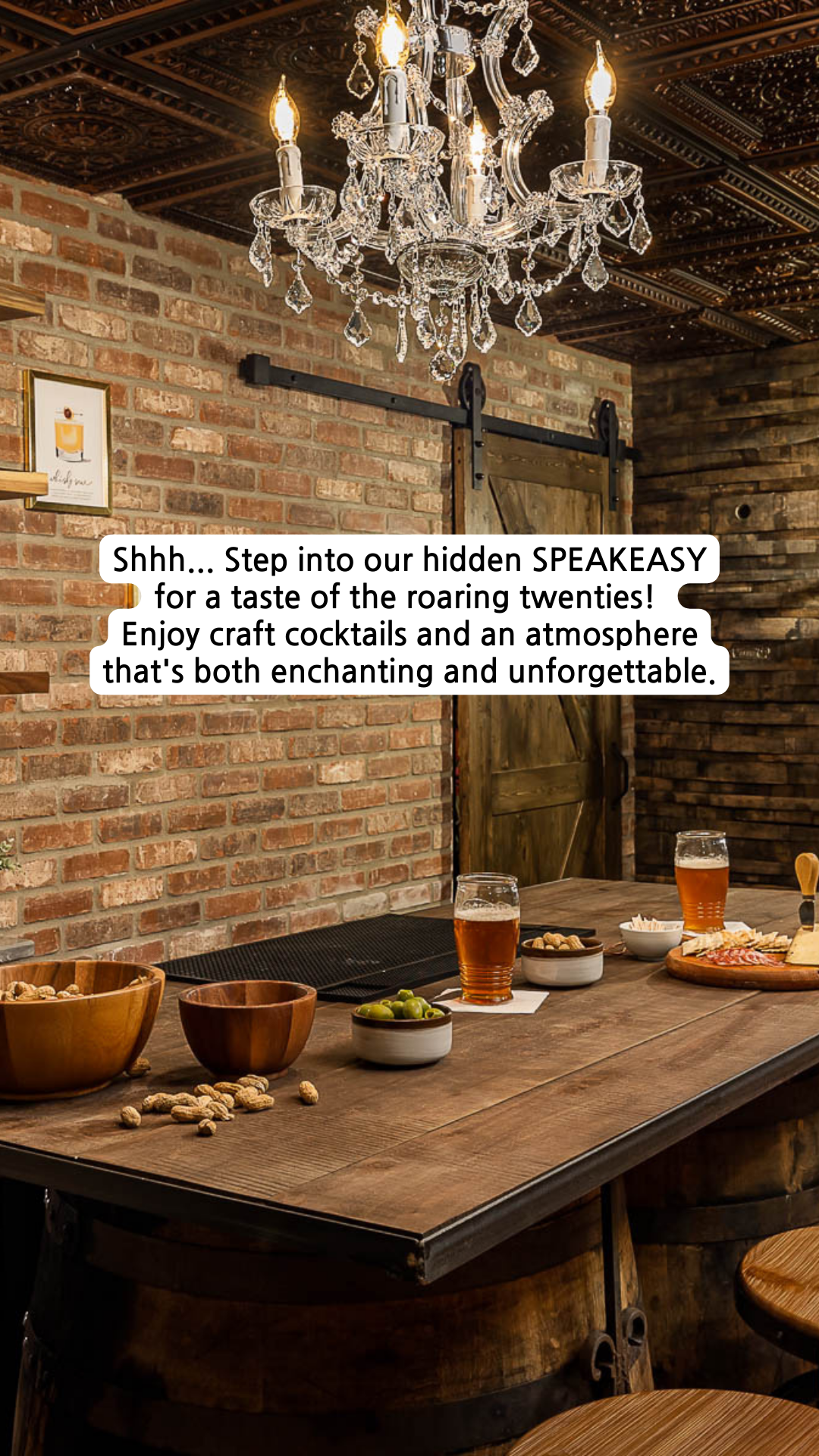 Speakeasy bar with cocktails, snacks, exposed brick wall, and chandelier.