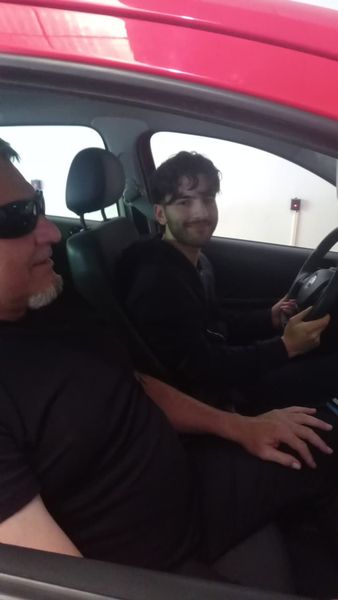 Dos personas sentadas en un coche: una al volante y otra en el asiento del copiloto.