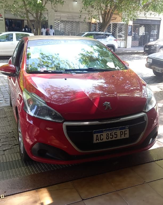 Dos personas en un coche: el conductor hace un gesto mientras el pasajero mira hacia delante en una calle de la ciudad