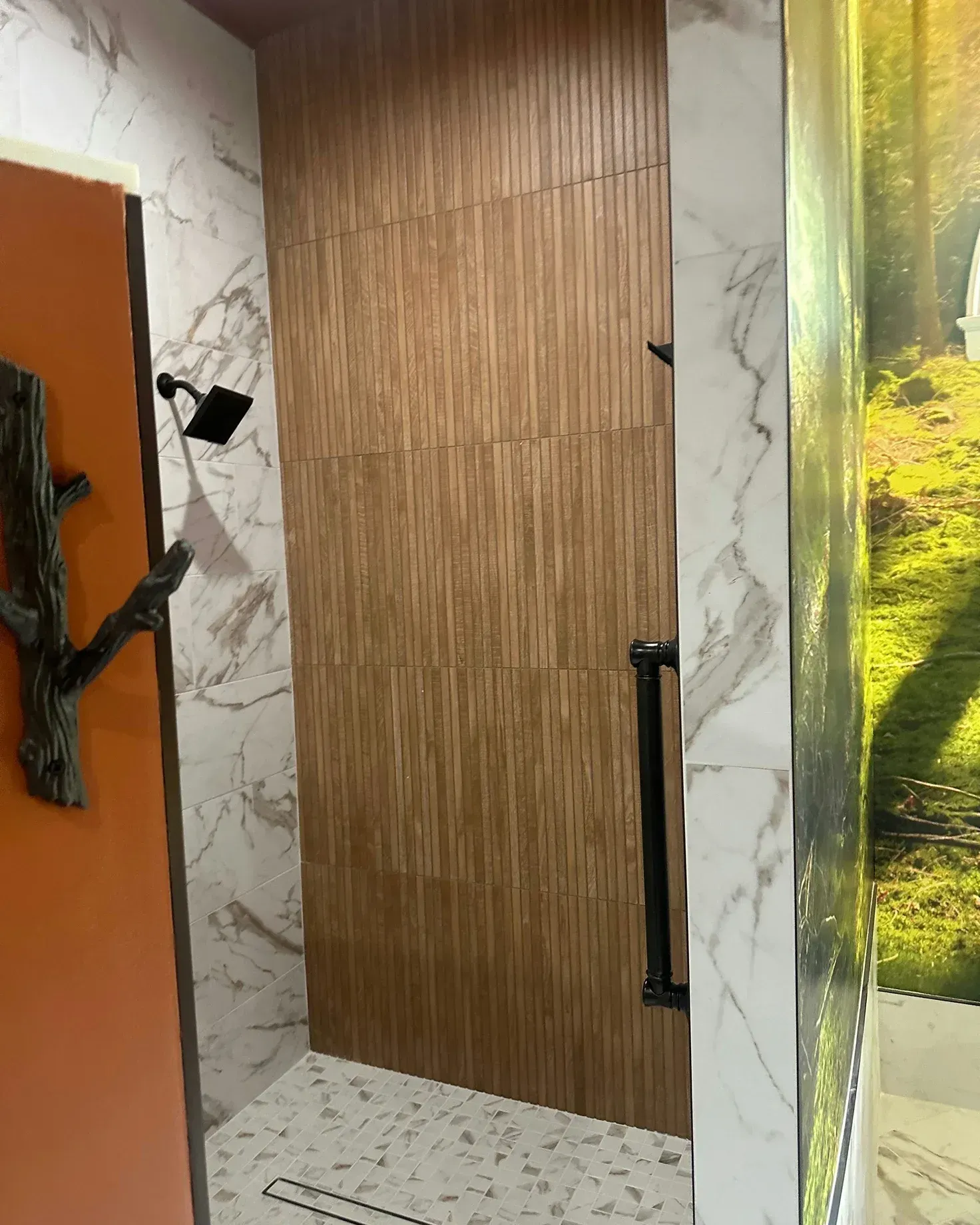 Wooden sliding door with black handle in a marble-patterned hallway.