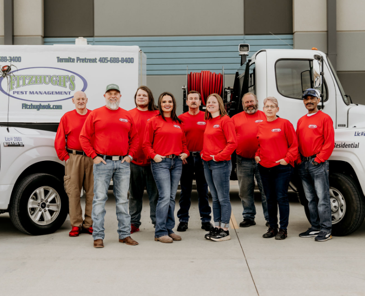 A group of people are posing for a picture in front of a truck.
