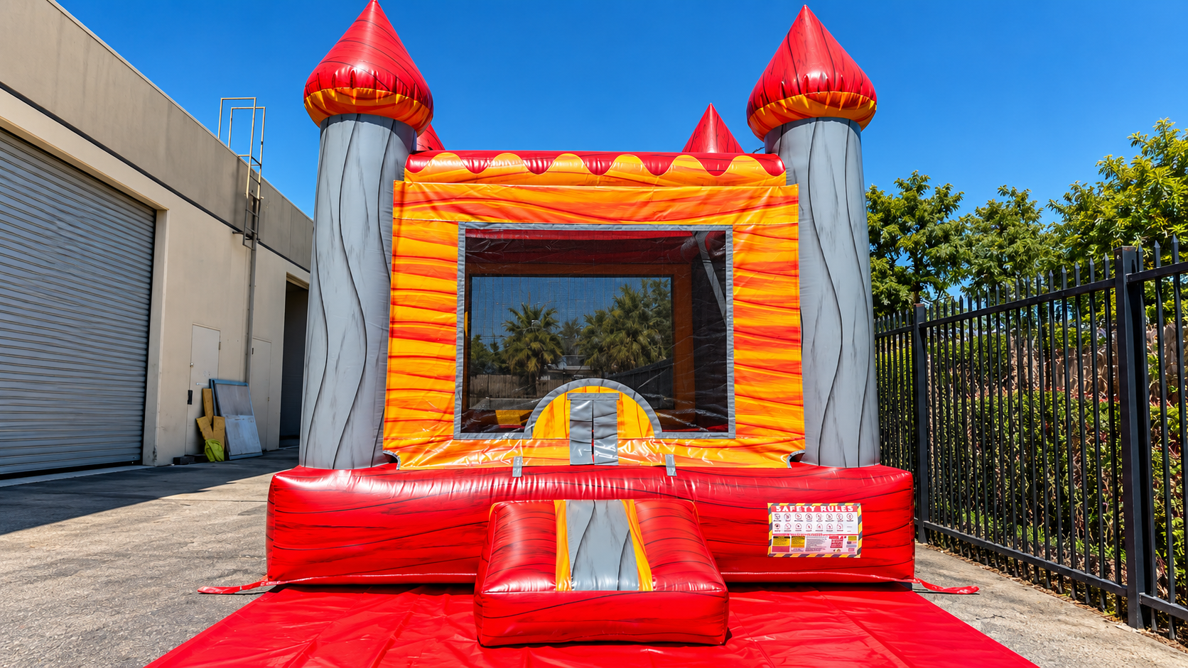 Colorful indoor inflatable playground with bounce houses, slides, and a shiny multicolored floor