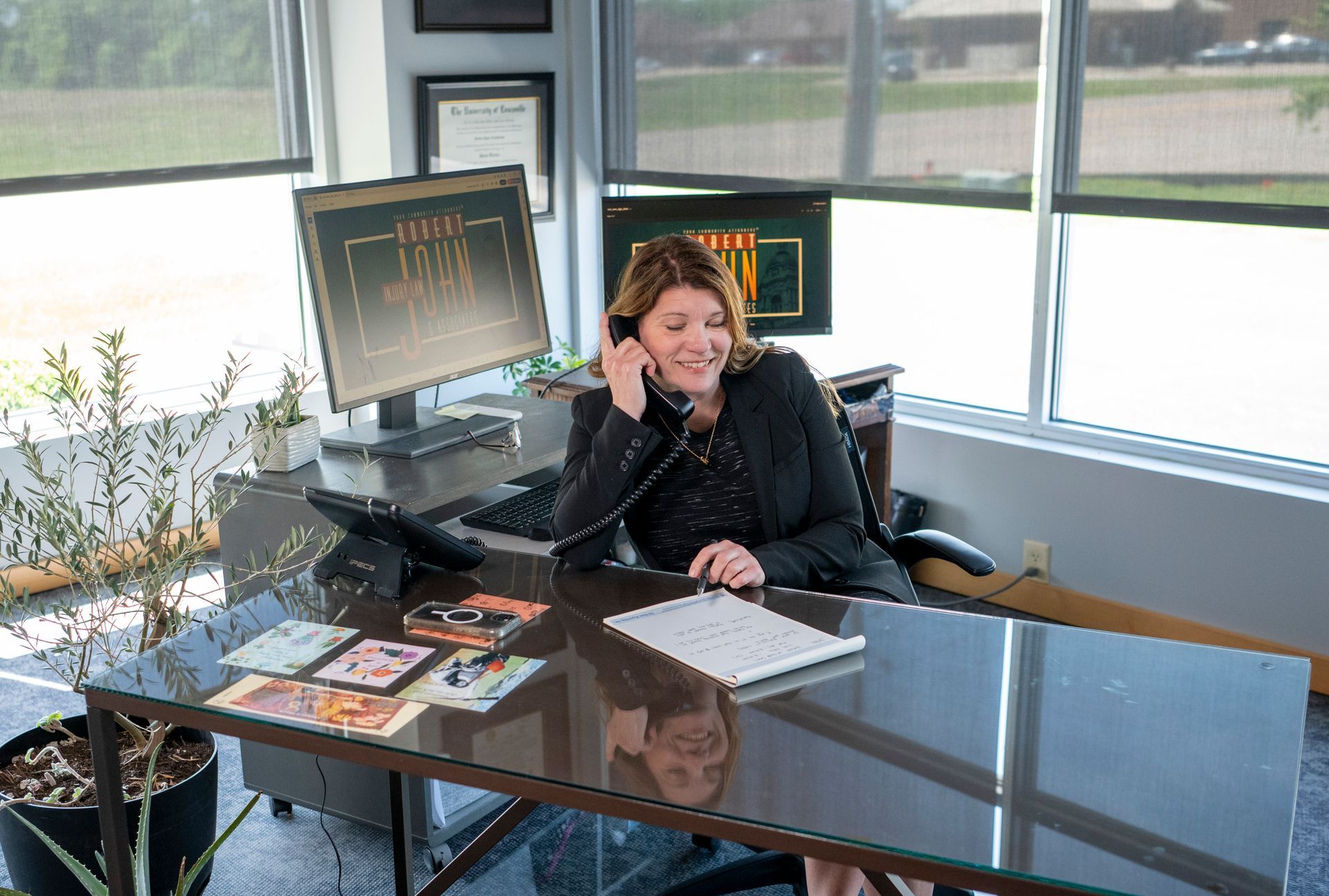 Sacha Armstrong smiling while talking on the phone in the office.