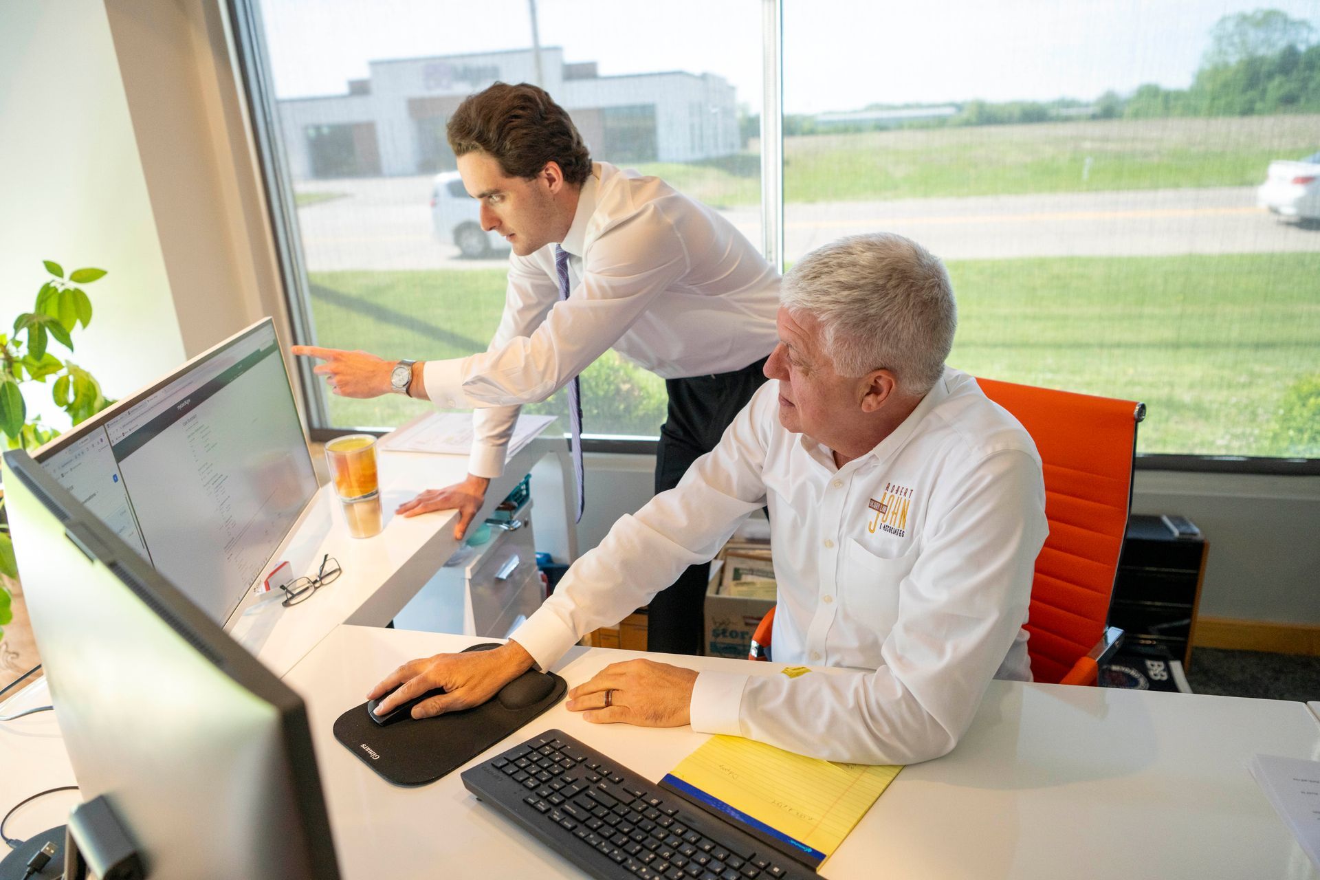 Rich Hawley and Will Marshall working together at a desk in the office.