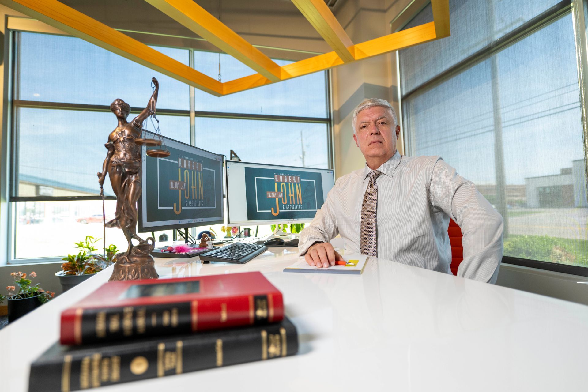 Rich Hawley formal seated office portrait with law books and Lady Justice.