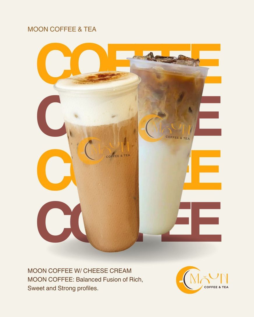 Tall glass of layered coffee drink with creamy foam, on a table before a blurred tree backdrop
