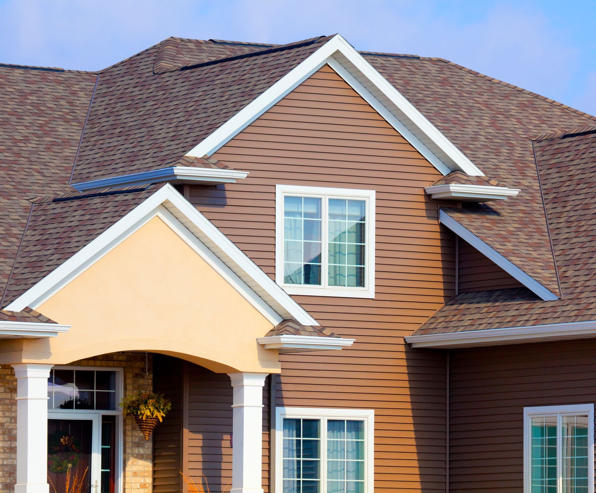 A brown house with a white trim and a brown roof