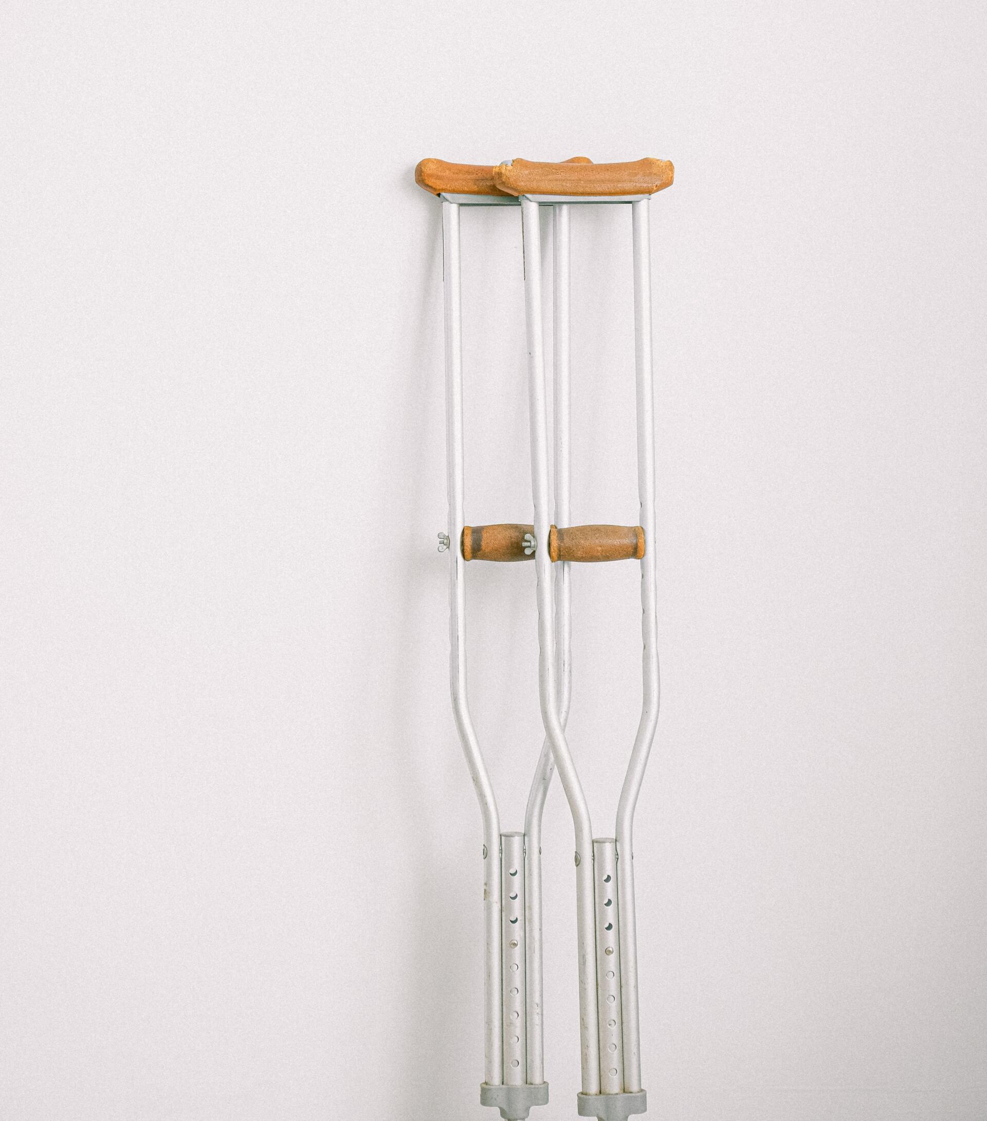 A pair of crutches hanging on a white wall