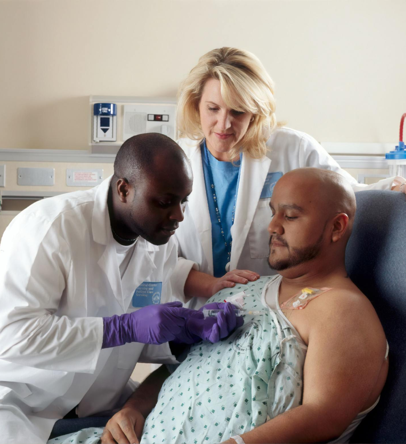 A man in a hospital gown is being examined by two doctors