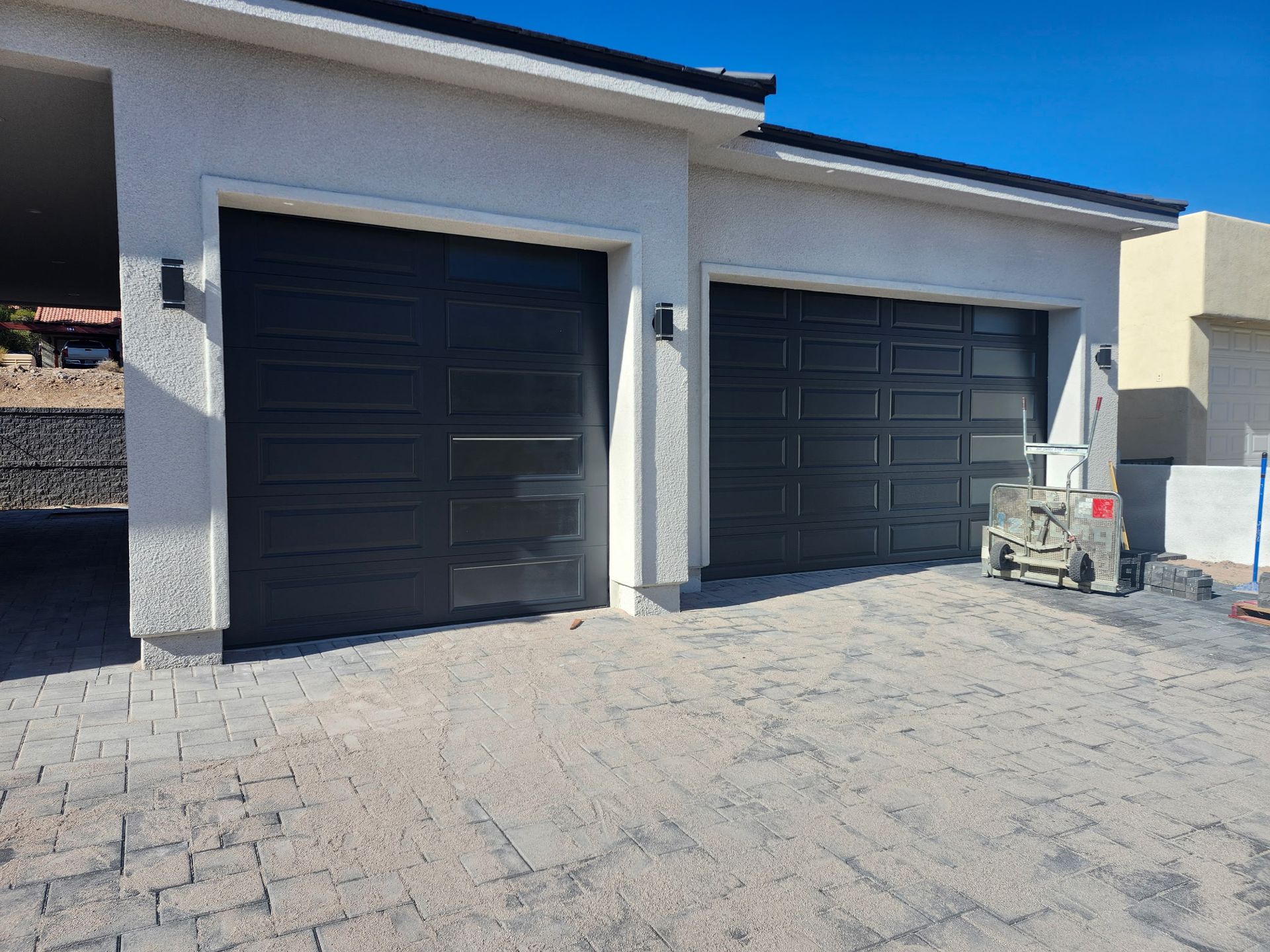 There are two garage doors on the side of a house.