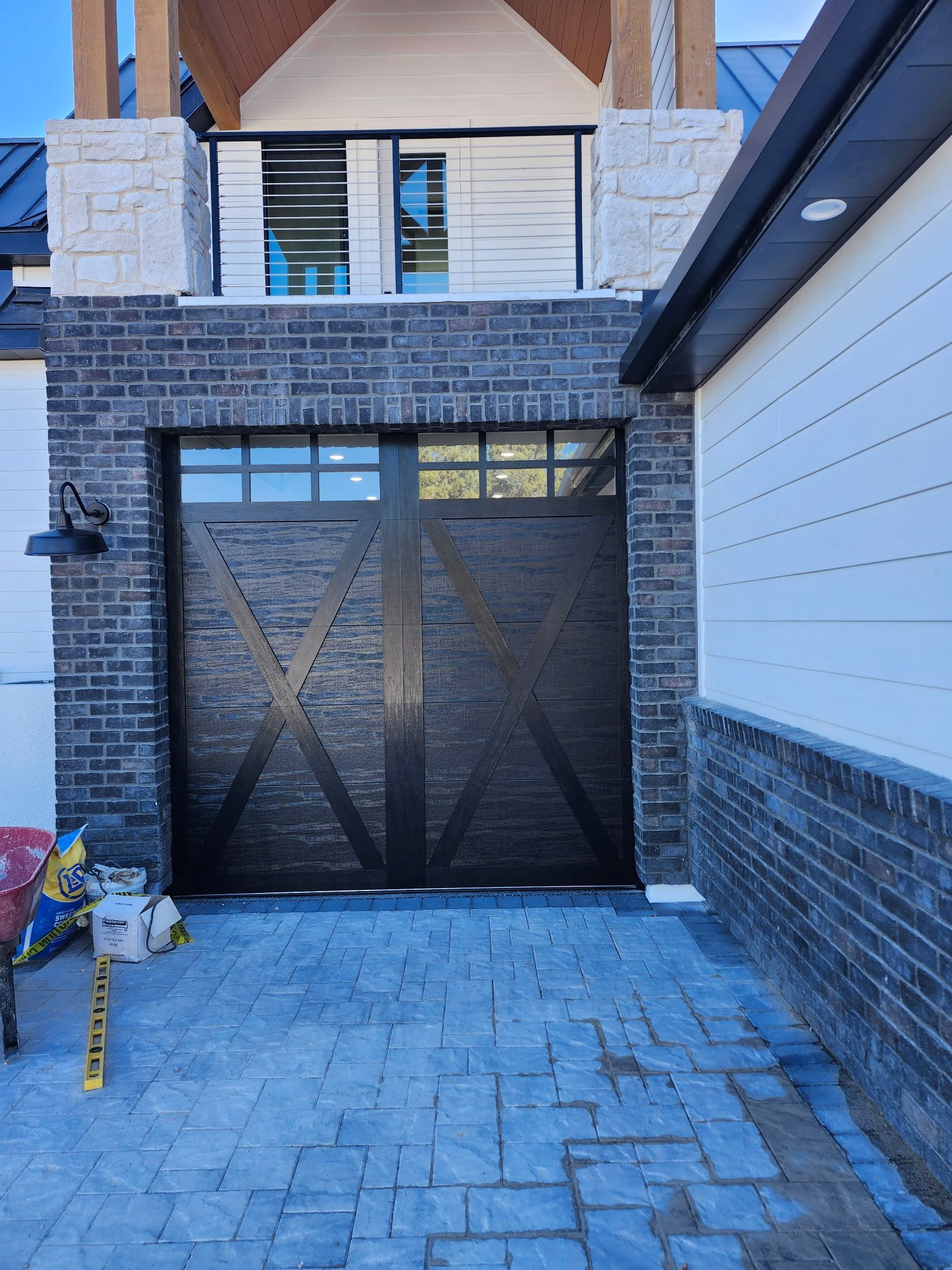A black garage door is sitting in front of a brick building.