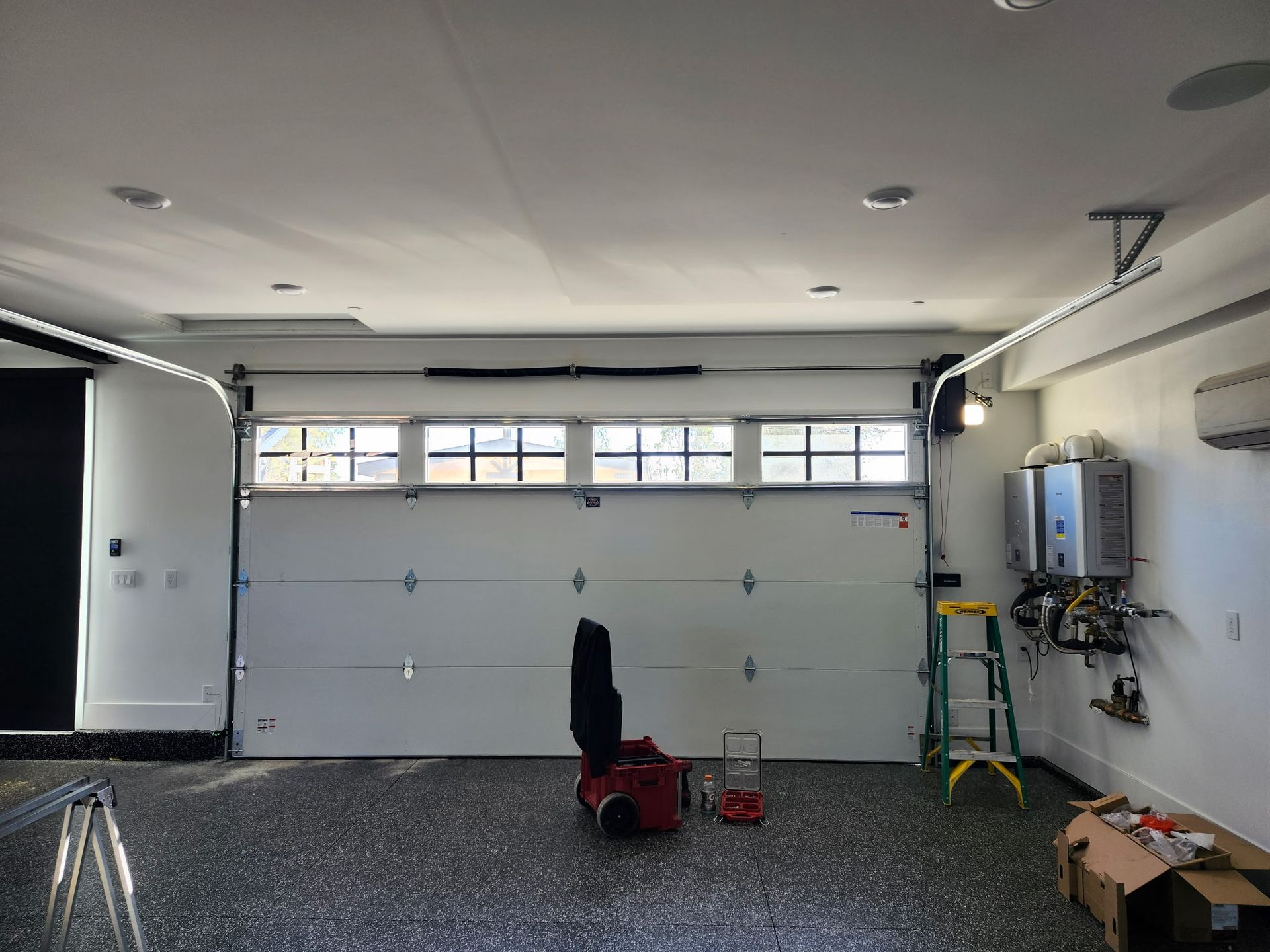 A garage with a white garage door and a ladder