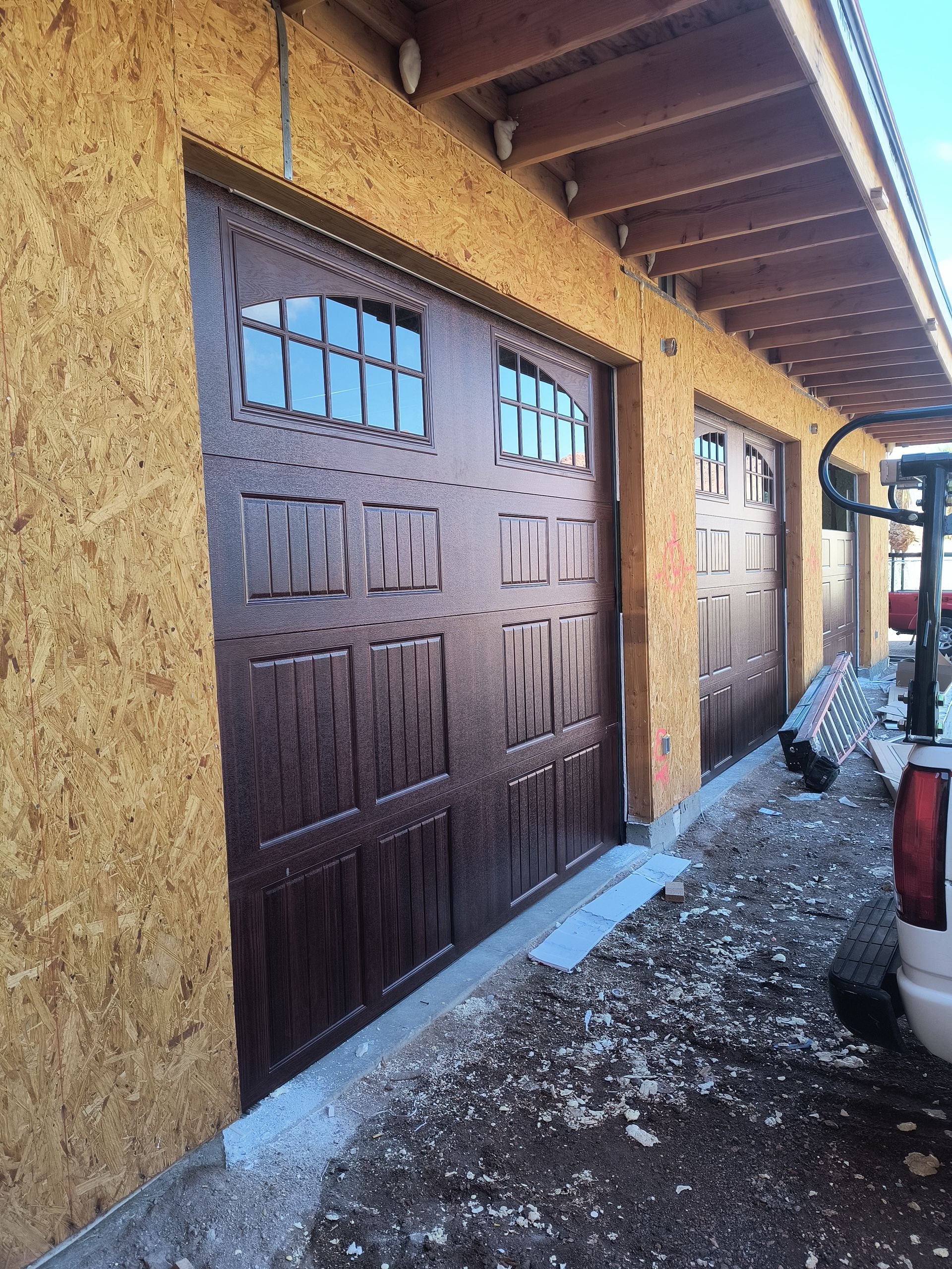 A truck is parked in front of a garage door.