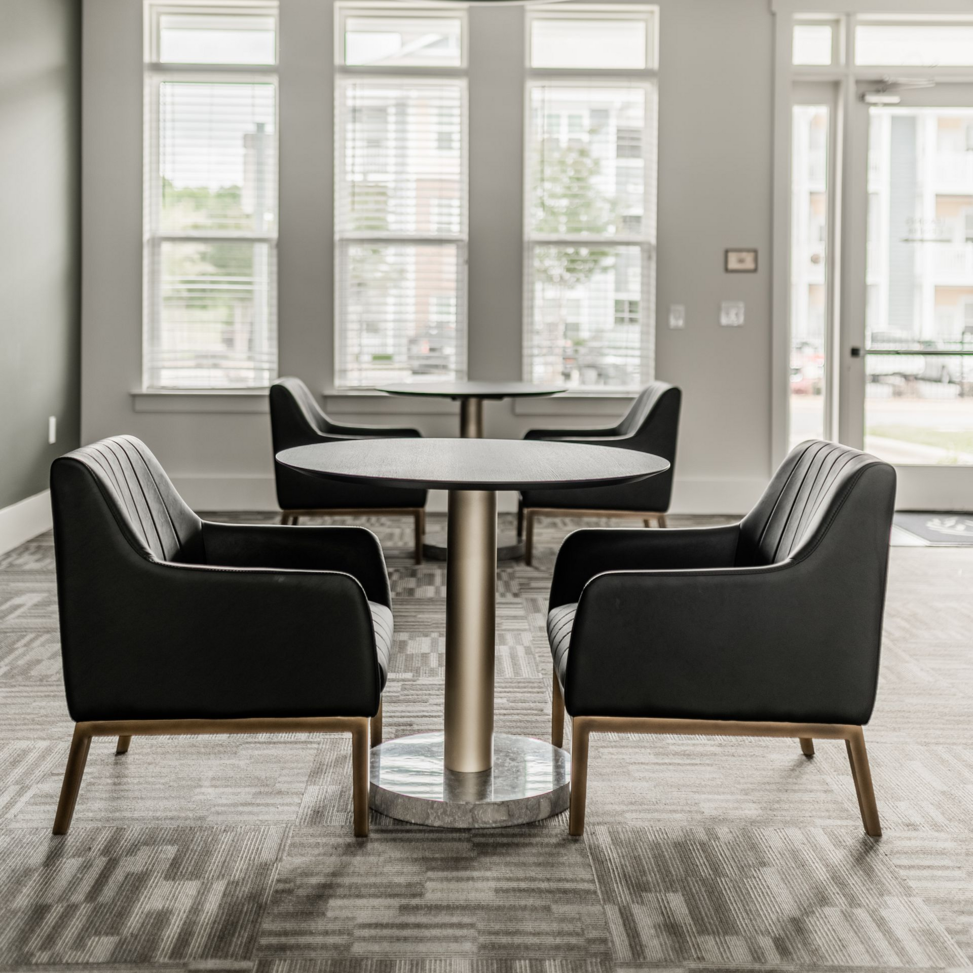 Modern dining nook with round table, four black chairs, and large windows in a bright room at Willows at Fort Mill apartments for rent in SC.