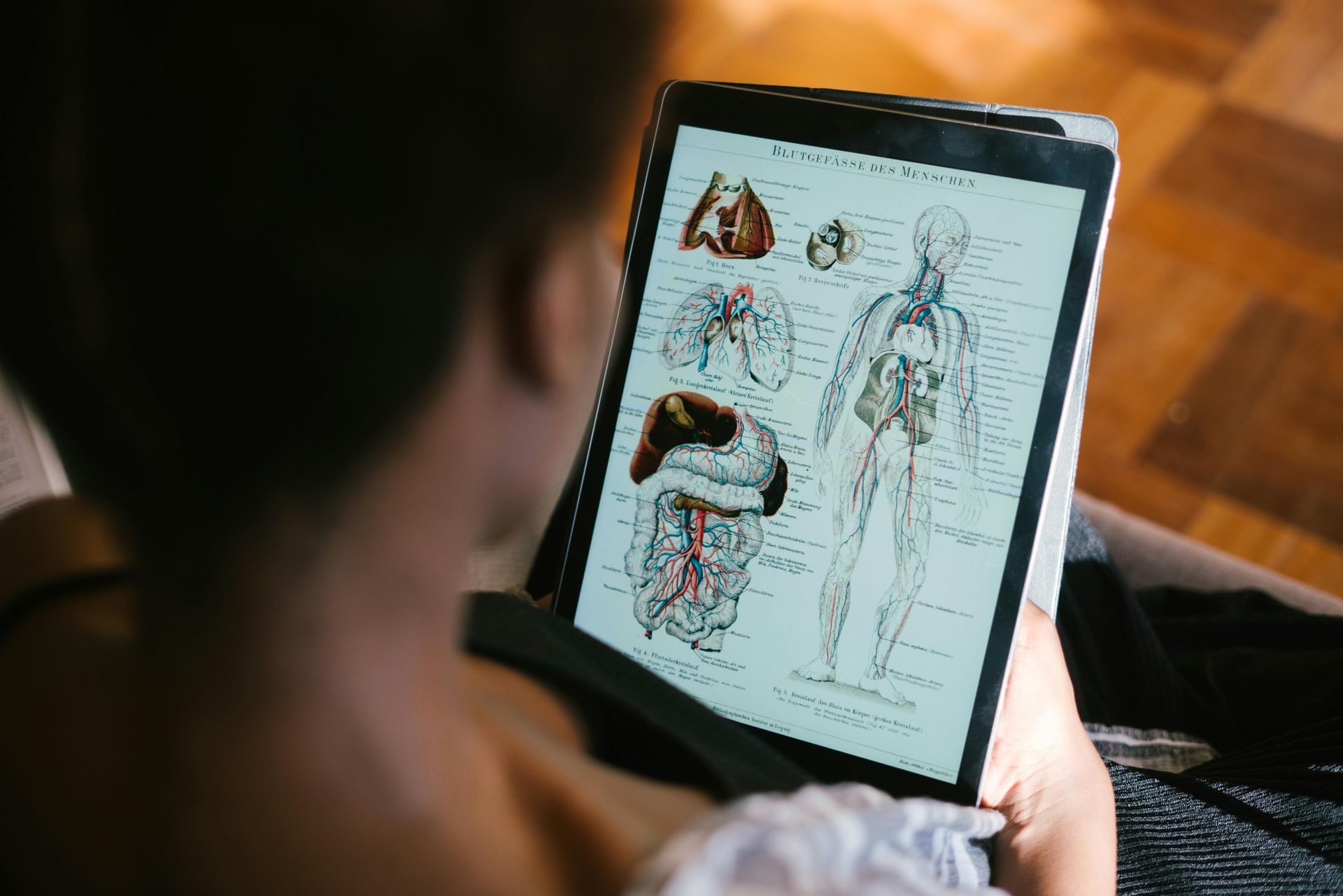 A person is holding a tablet with a diagram of the human body on it.