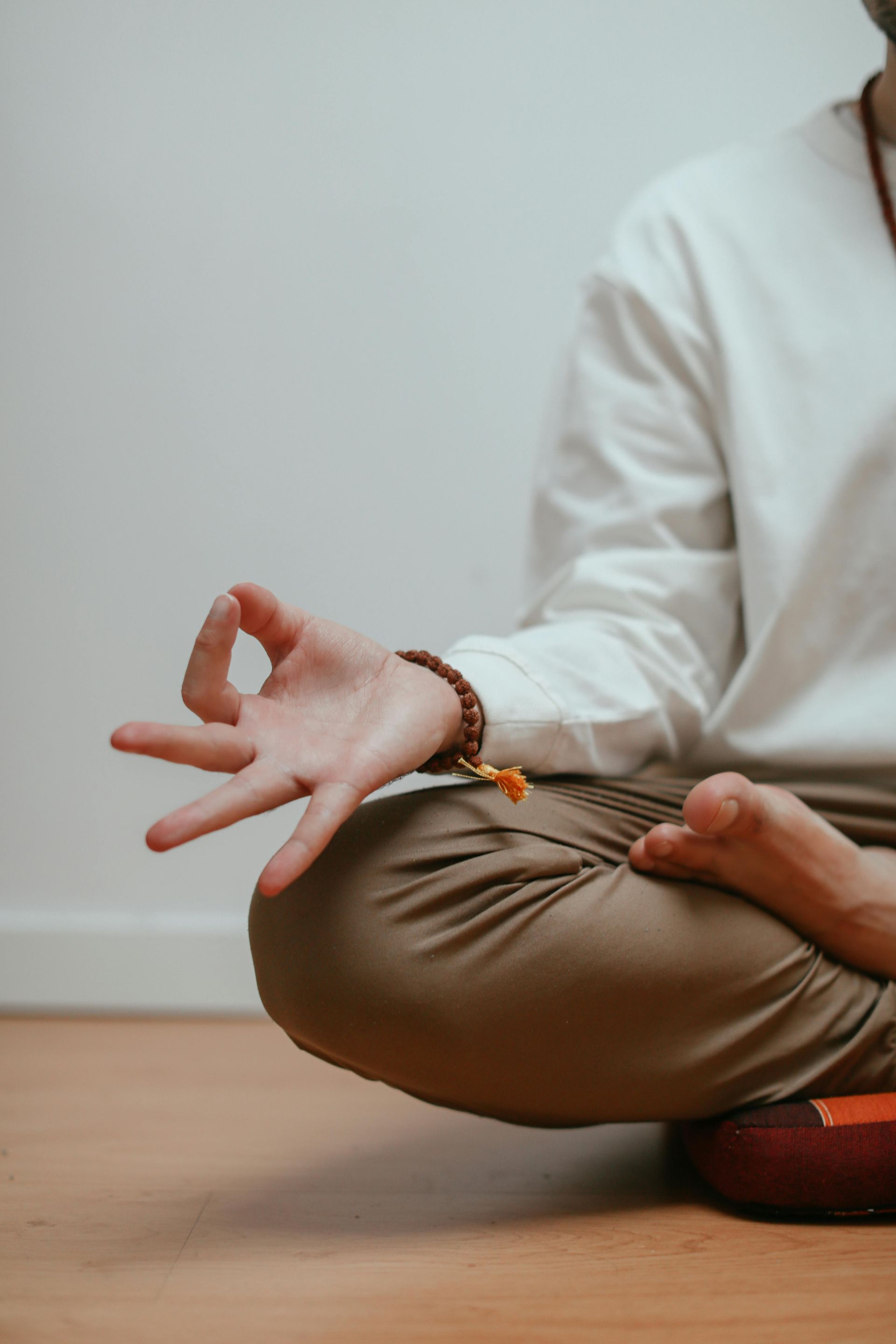 A woman is sitting on the ground with her hands on her chest.
