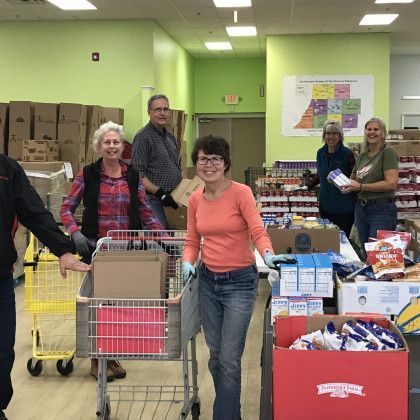 A group of people are standing in a store holding shopping carts.