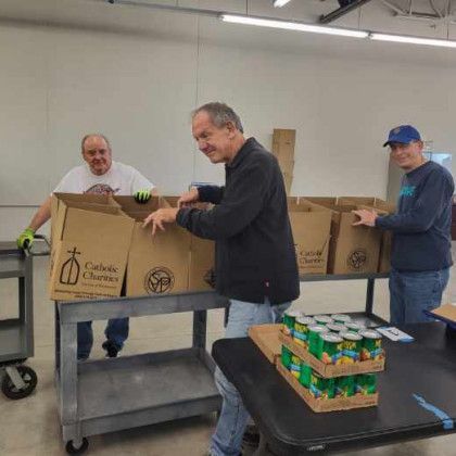 A group of men are working in a room with boxes and cans.