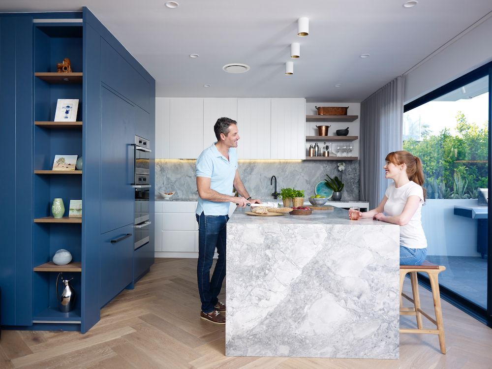 Family sitting in kitchen enjoying cool ducted reverse cycle air