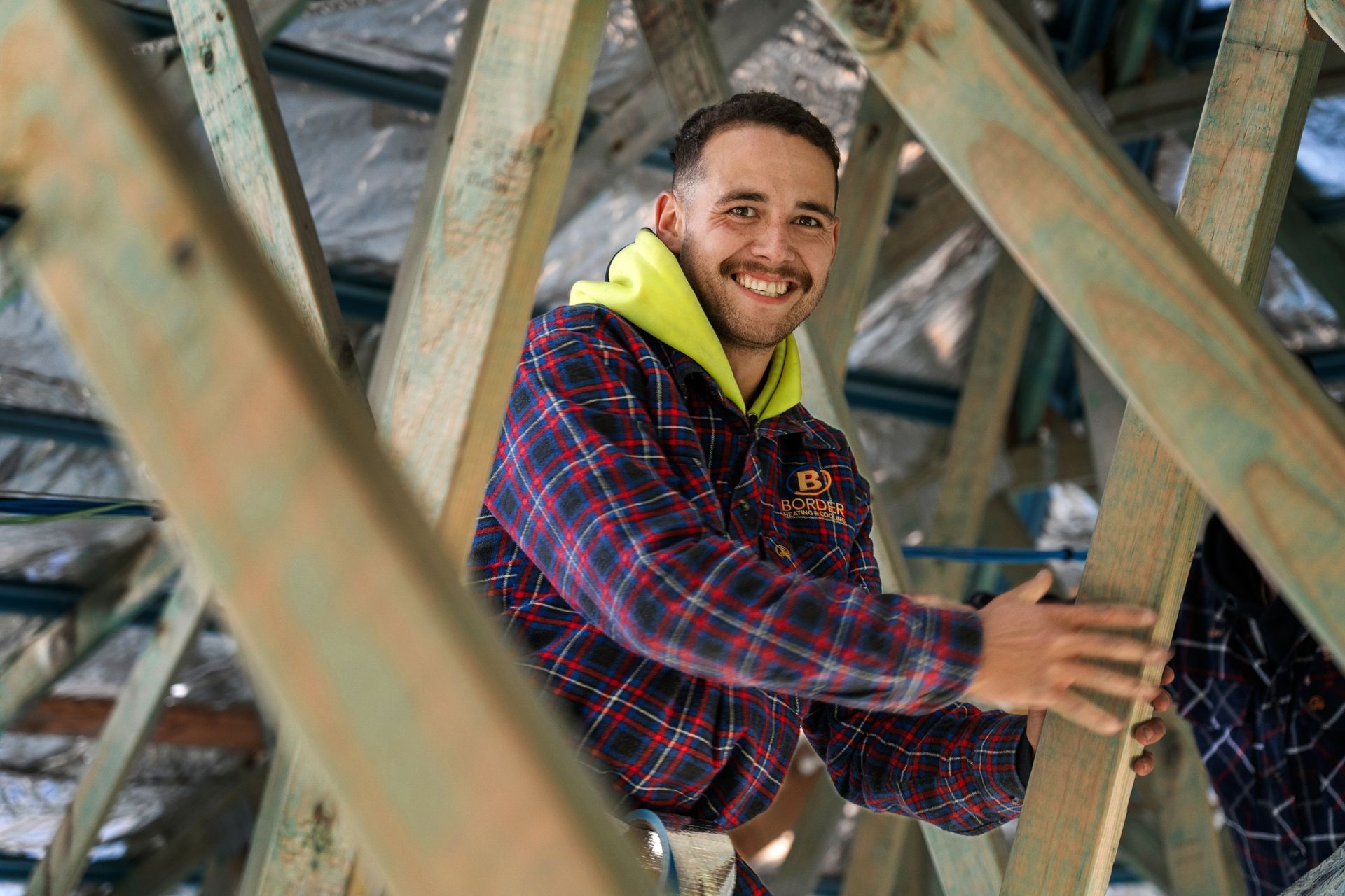 Smiling HVAC installer in a roof 