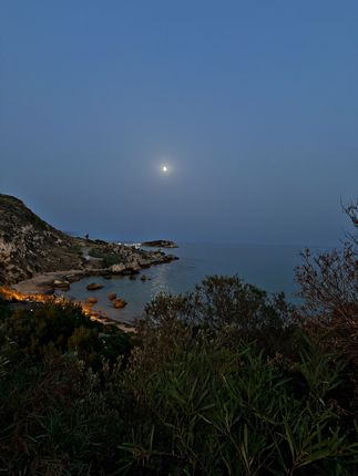 Una luna piena splende su uno specchio d'acqua