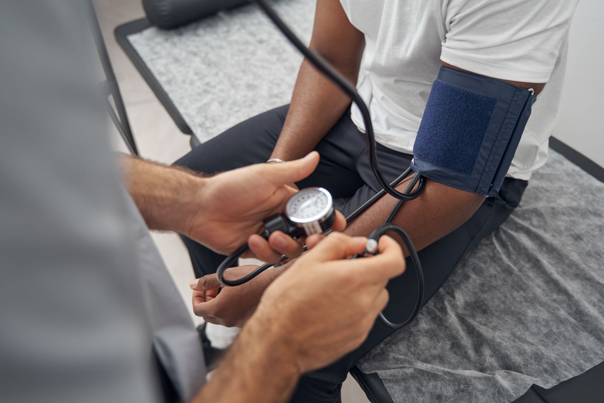 Healthcare worker checking a patient’s blood pressure during a clinic visit.