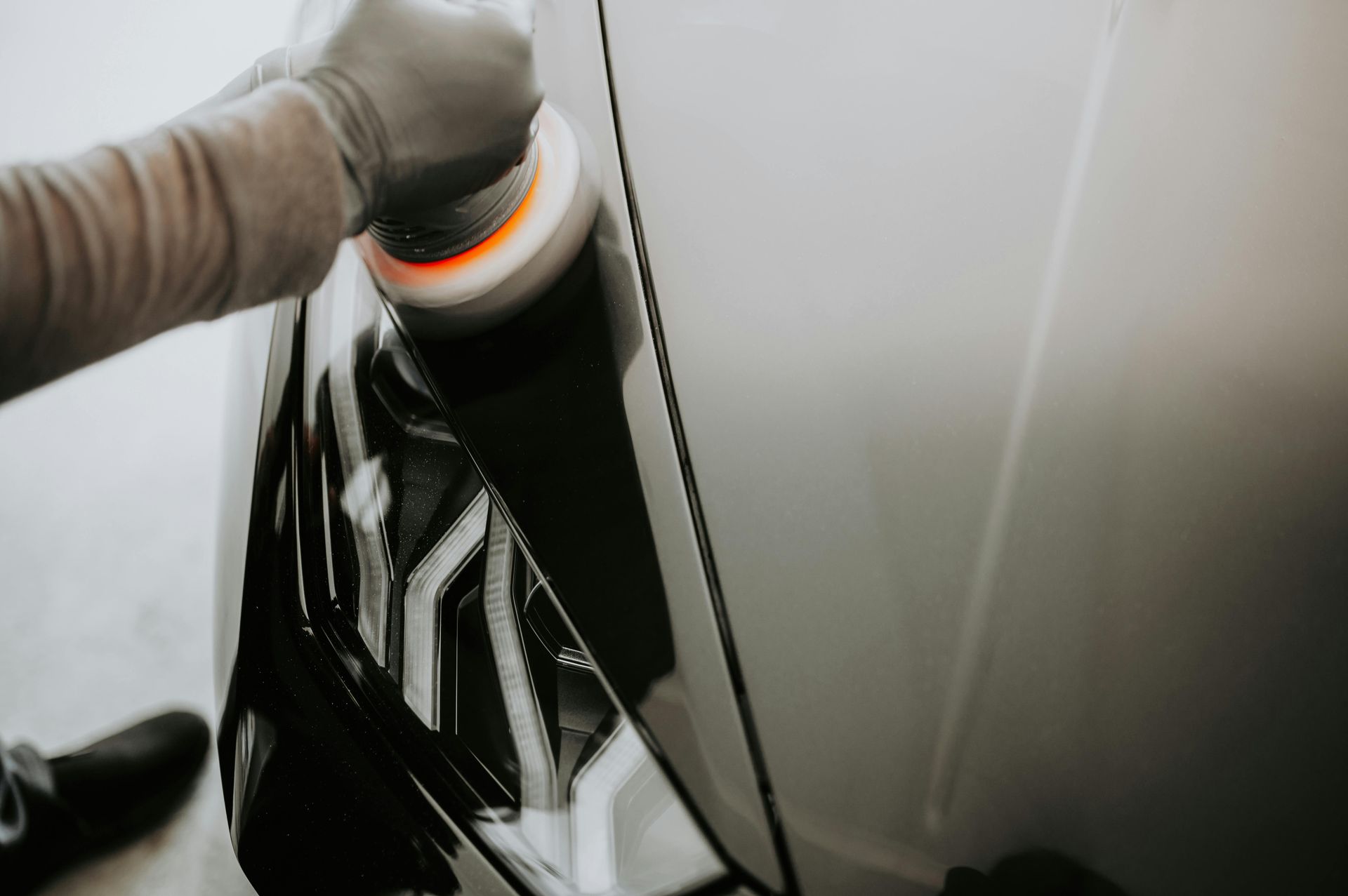 A person is polishing a car with a polisher.