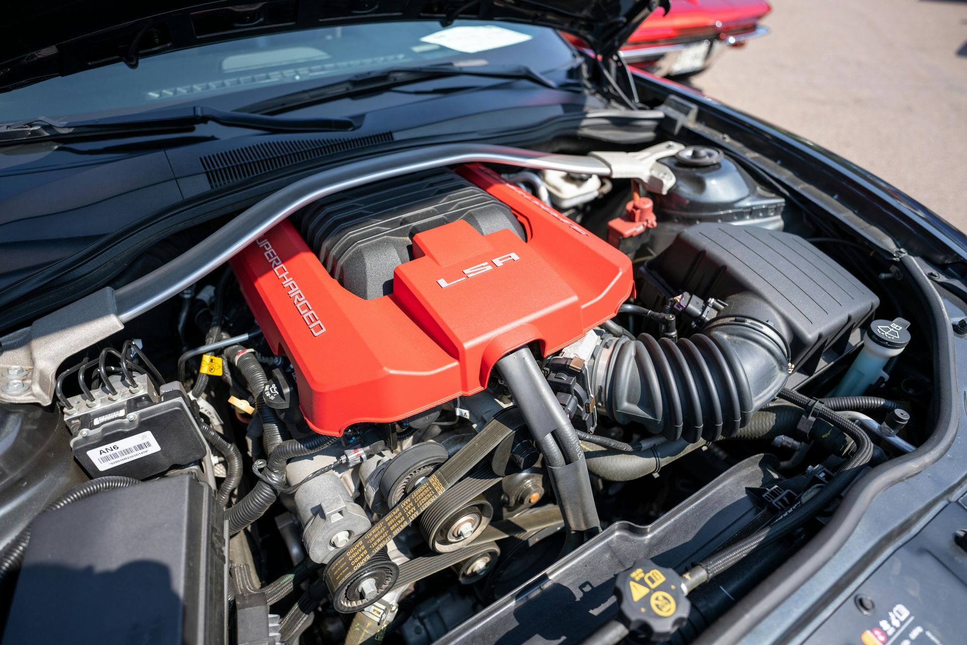 A close up of a car engine with the hood open.