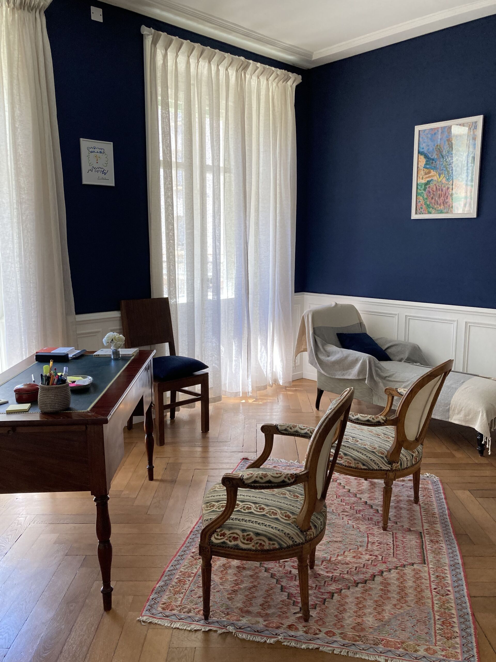 Un salon avec un bureau, des chaises et un tapis.
