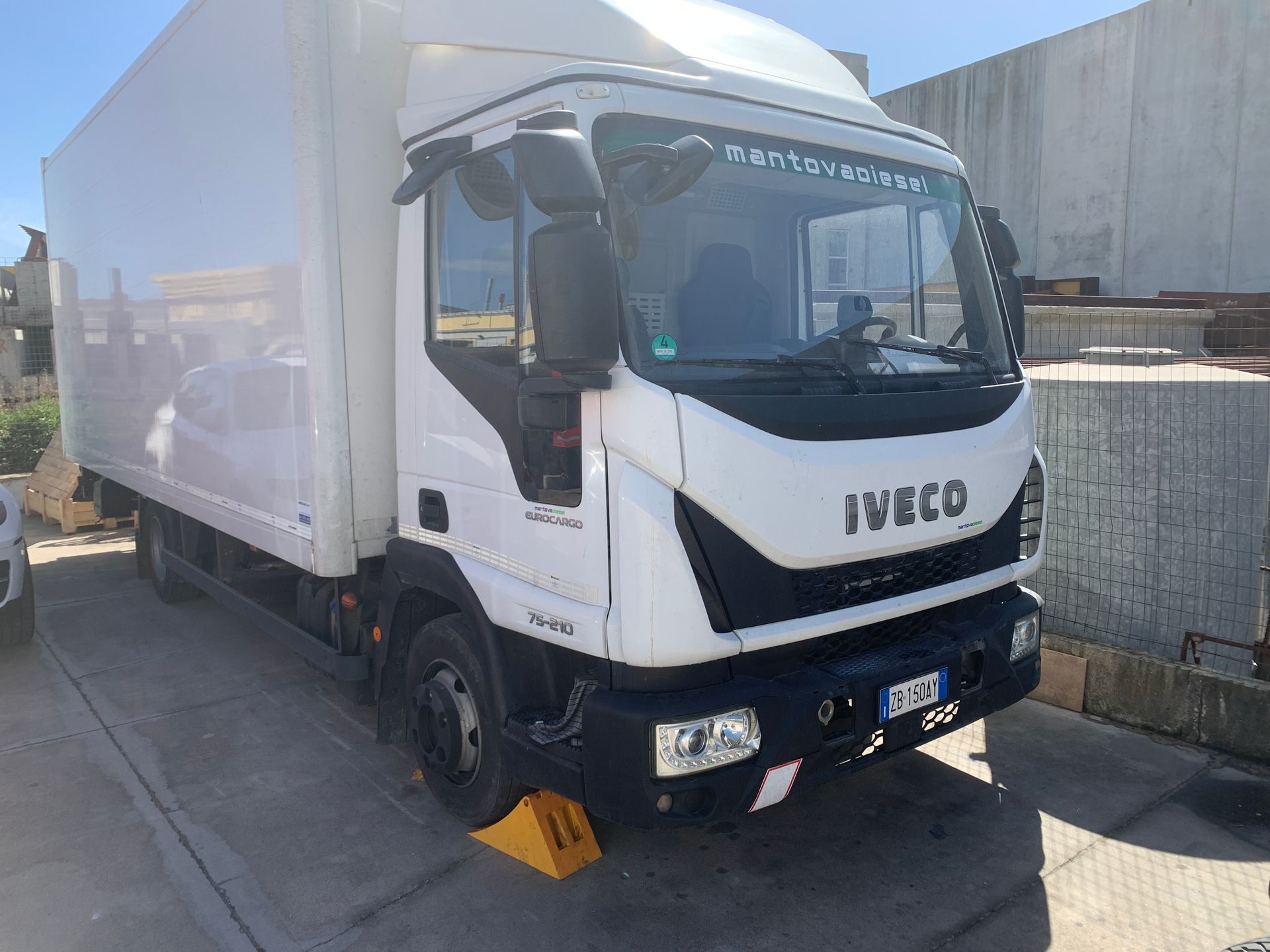 Un camion iveco bianco è parcheggiato sul lato della strada.
