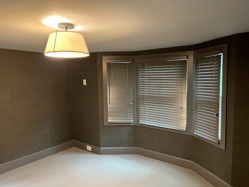 There is a lamp hanging from the ceiling in the corner of the room.