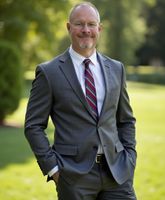 A man in a suit and tie with his hands in his pockets