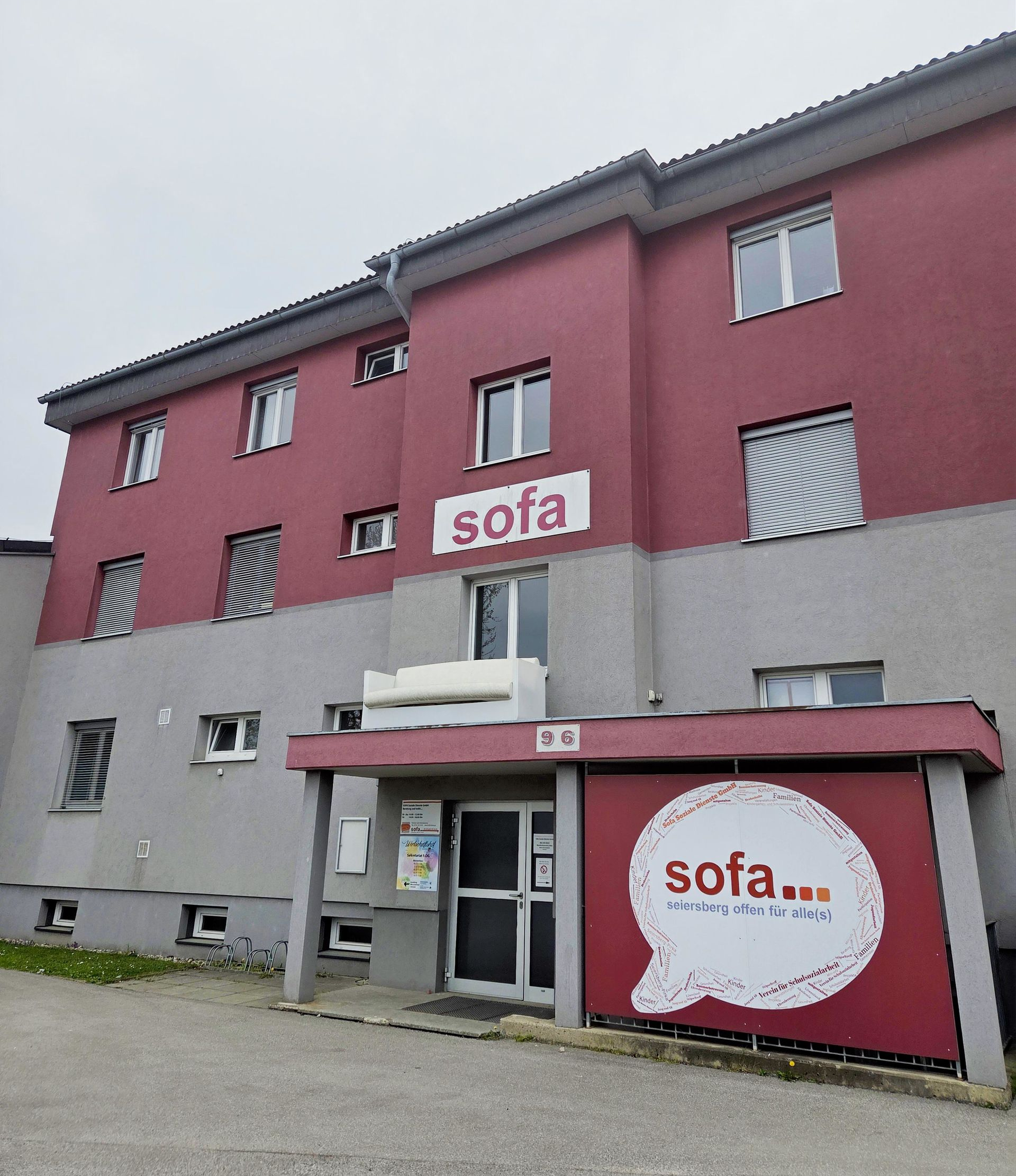 Gebäude eines Sofageschäfts in Rot und Grau mit Logo-Beschriftung an der Vorderseite.