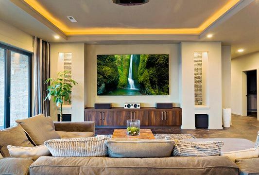 There is a picture of a waterfall on the wall in the living room.
