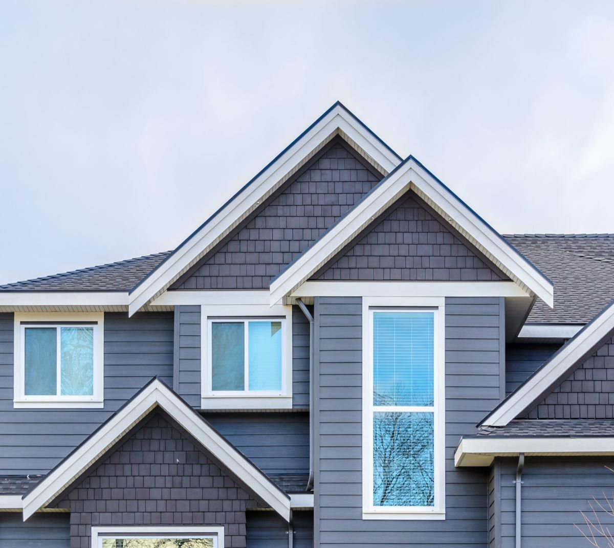 A large gray house with white trim and a gray roof