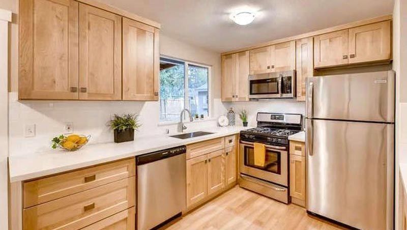 A kitchen with stainless steel appliances and wooden cabinets.