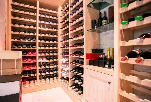 A wine cellar filled with lots of wine bottles on shelves.