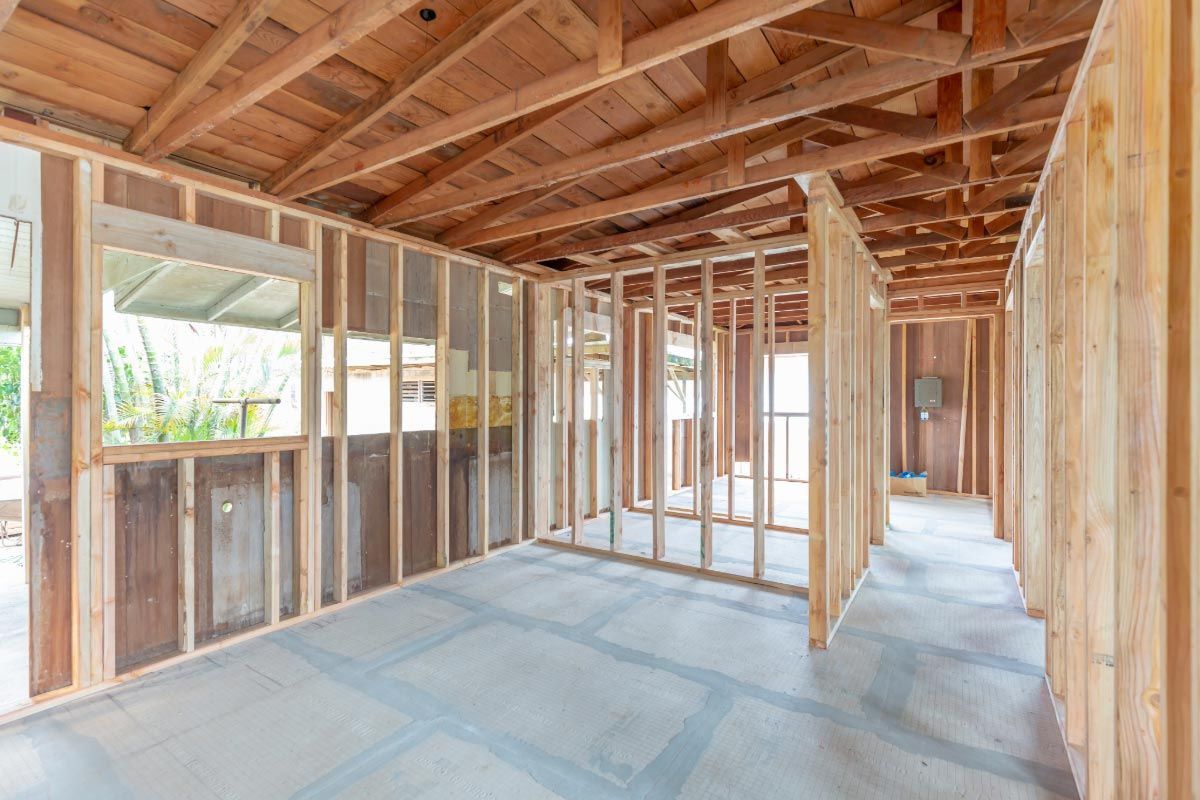 An empty room in a house under construction with wooden beams.