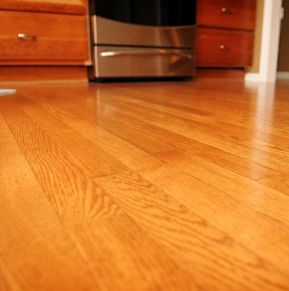 A kitchen with hardwood floors and a stainless steel stove