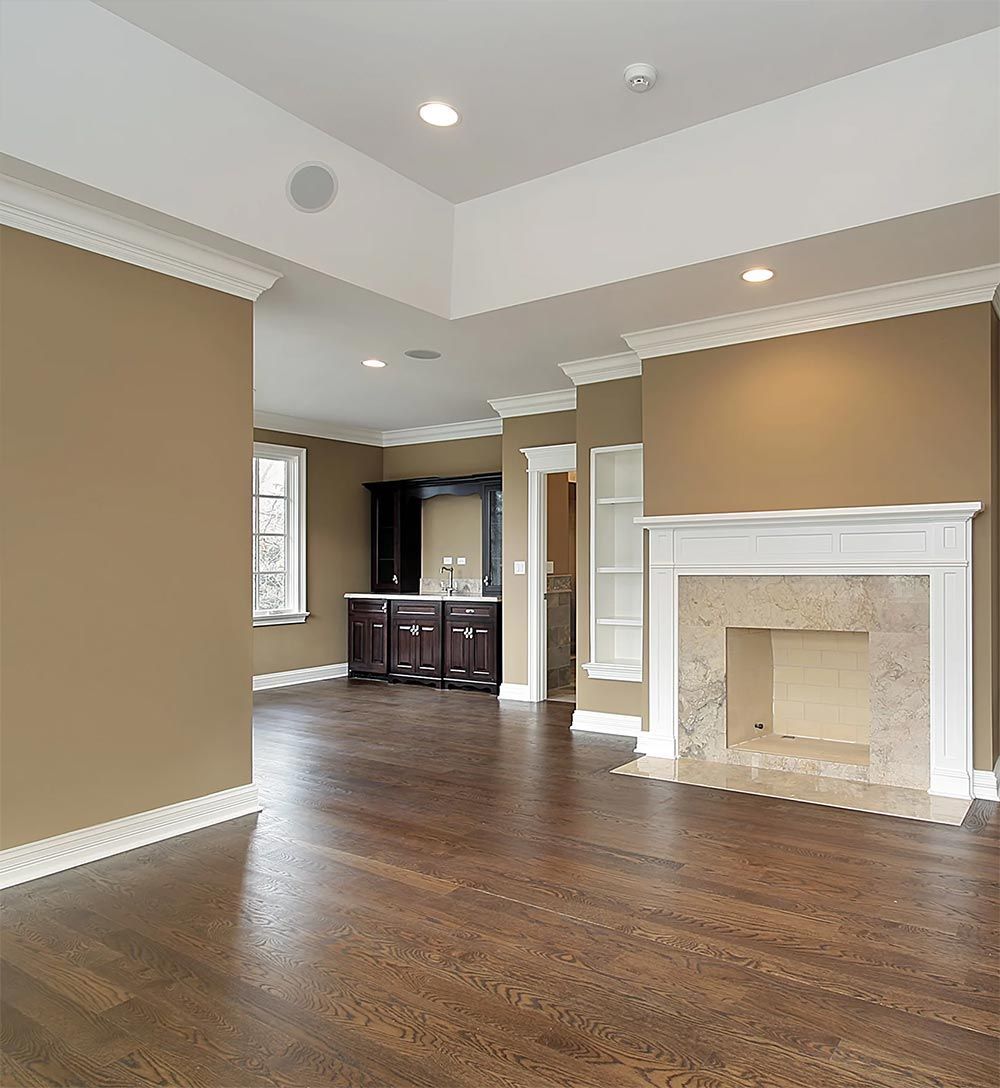 An empty living room with hardwood floors and a fireplace.
