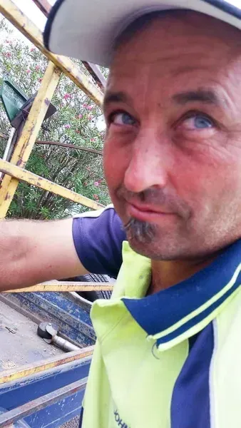 Man in Cap, Yellow Vest, and Blue Shirt — John's Tree Lopping in Belmont, NSW