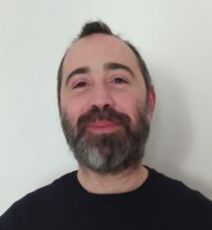 Un uomo con la barba indossa una camicia nera