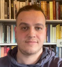 Un uomo davanti a una libreria con un cartello che dice c.