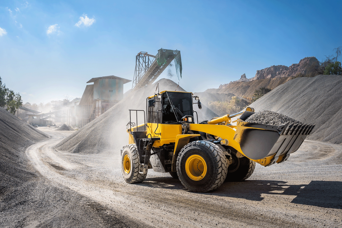 A Yellow Bulldozer Is Driving Down A Dirt Road — Welch, MN — Luhman's Construction Co.