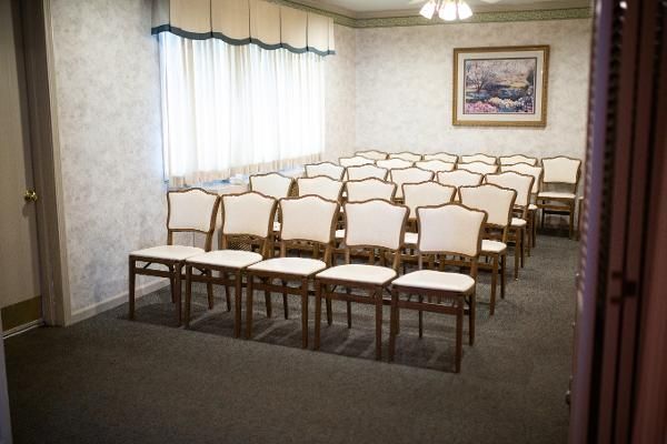 Empty church meeting room with rows of white chairs facing the front
