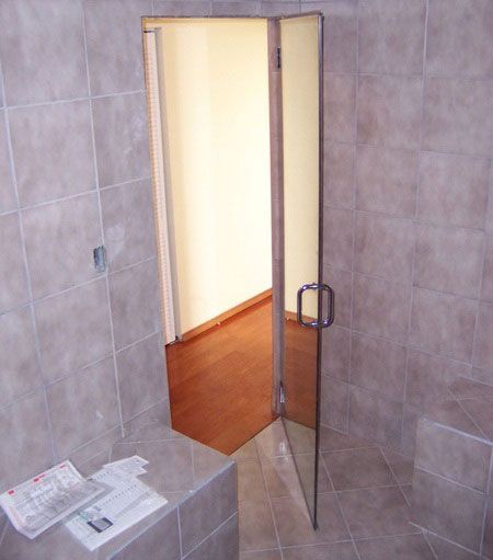 A bathroom with a glass door that is open