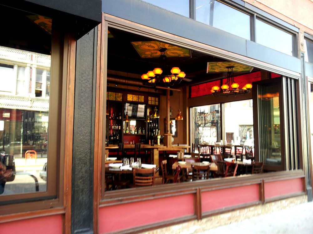 A restaurant with tables and chairs in front of a large window